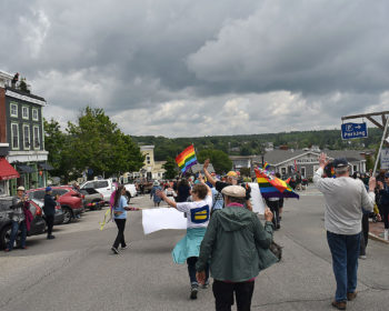 2023 Belfast Pride Parade marchers waving rainbow flags