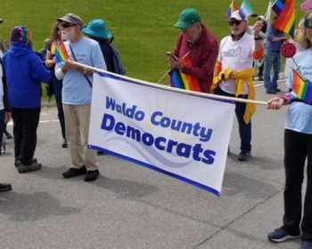 The Waldo County Democrats blue and white banner held by Bernie and Laura Baker