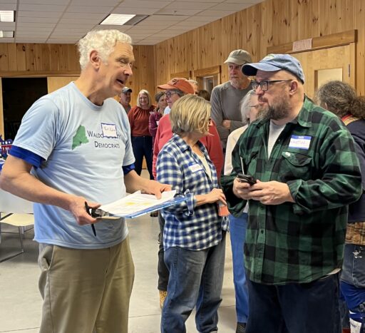 With clipboard in hand, Paul talks with Martin at the spring potluck, in front of line for the buffet
