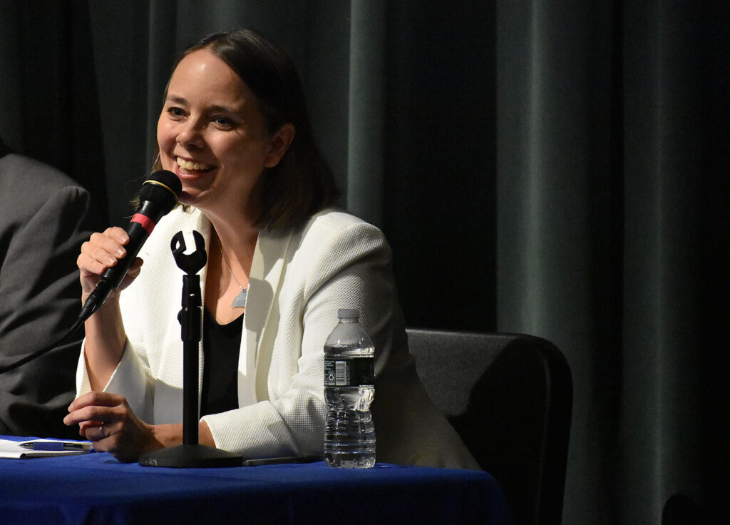 Candidate Shenna Bellows, wearing a white blazer, at the microphone.