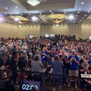 View of Senate Nominating Convention floor from the stage, showing nearly 600 delegates plus press in the foreground and background.